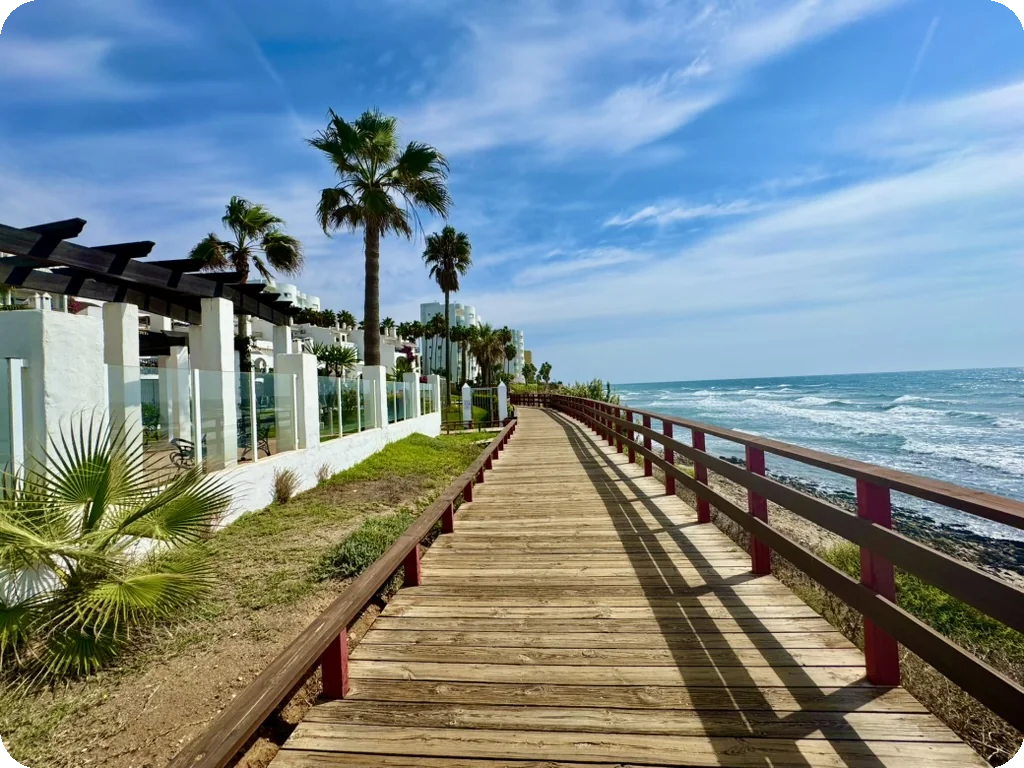 Promenade piétonne en bois en bord de mer sur la Costa del Sol, environnement résidentiel et touristique